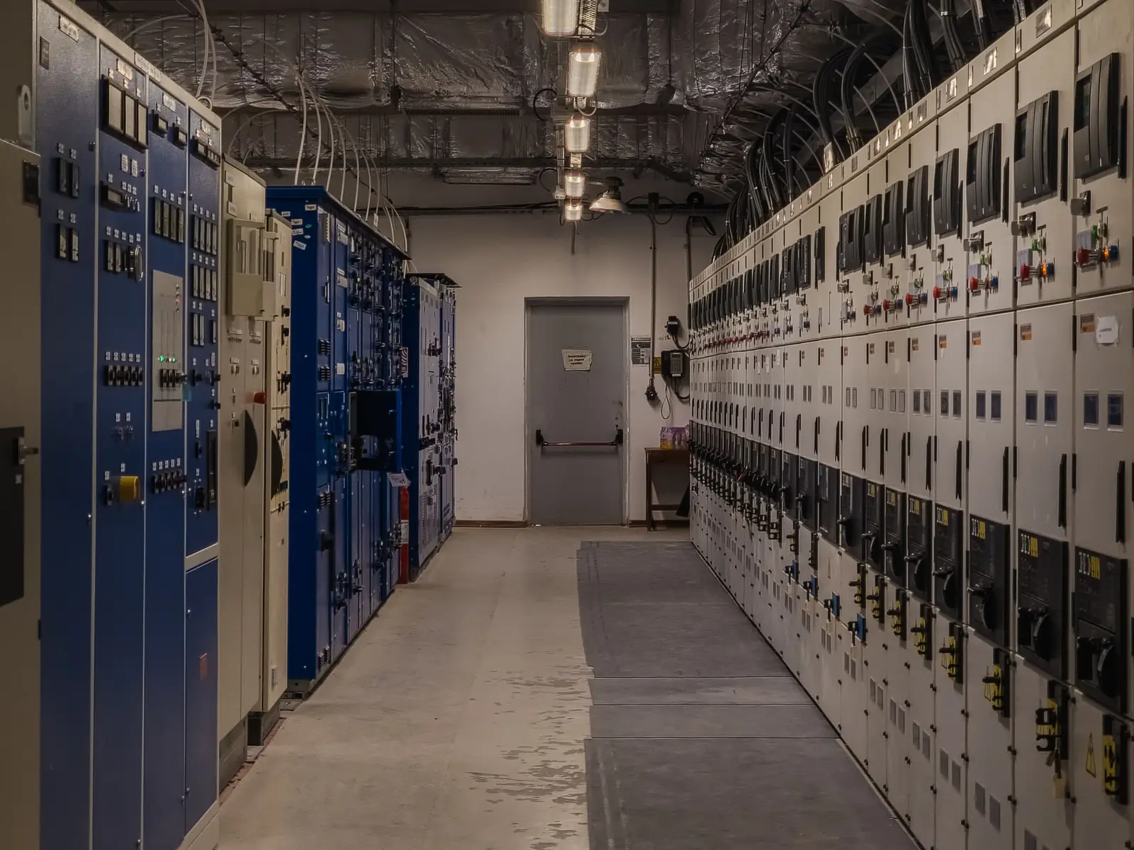 Cuadro eléctrico industrial abierto con subcuadros y cableado ordenado en una nave