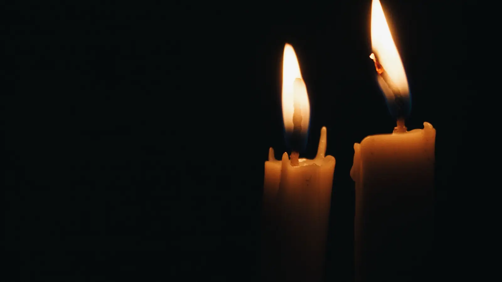 Dos velas encendidas como única luz en una habitación completamente a oscuras